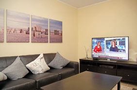 Wohnzimmer mit Sofa, Sessel und Kabel TV