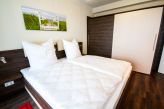 Schlafzimmer 1 mit Doppelbett, Zugang zum Duschbad und Zugang zum Süd Balkon