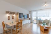 Wohnzimmer mit TV und Zugang zum Balkon