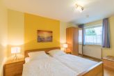 Schlafzimmer mit Doppelbett und Kleiderschrank