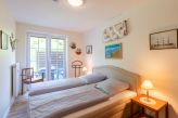 Schlafzimmer mit Doppelbett und Zugang zur Terrasse