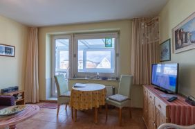 Wohnzimmer mit Essplatz und Zugang zur verglasten Loggia