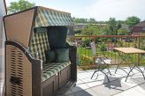 Balkon mit Strandkorb und Gartenmöbeln