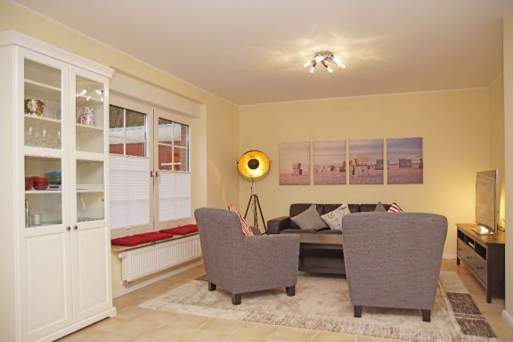 Wohnzimmer mit Sofa, Sessel und Kabel TV