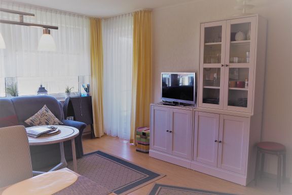 Wohnzimmer mit TV und Zugang zum Balkon