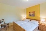 Schlafzimmer mit Doppelbett und Kleiderschrank